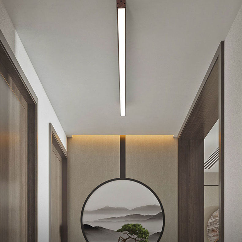 Walnut linear LED flush mount light against a curtained bedroom ceiling