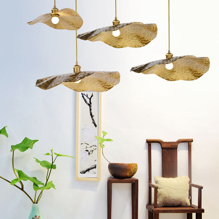 Golden lotus leaf pendants above a scroll painting and wooden armchair