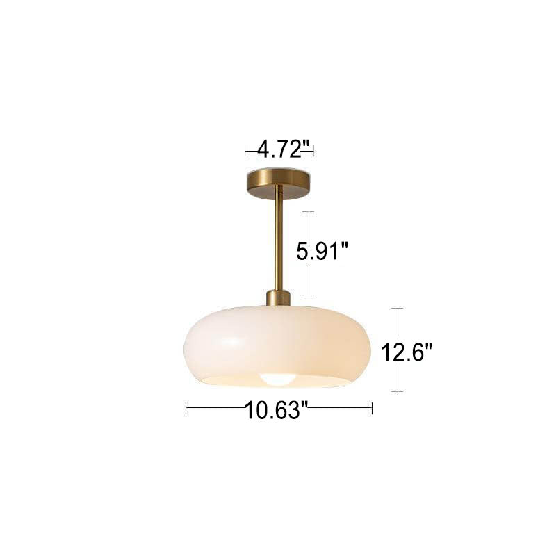 Amber glass flush mount ceiling light lit in a styled room setting