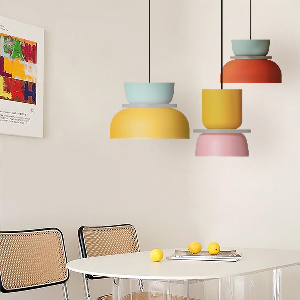 Three colorful pendant lights above a dining setting