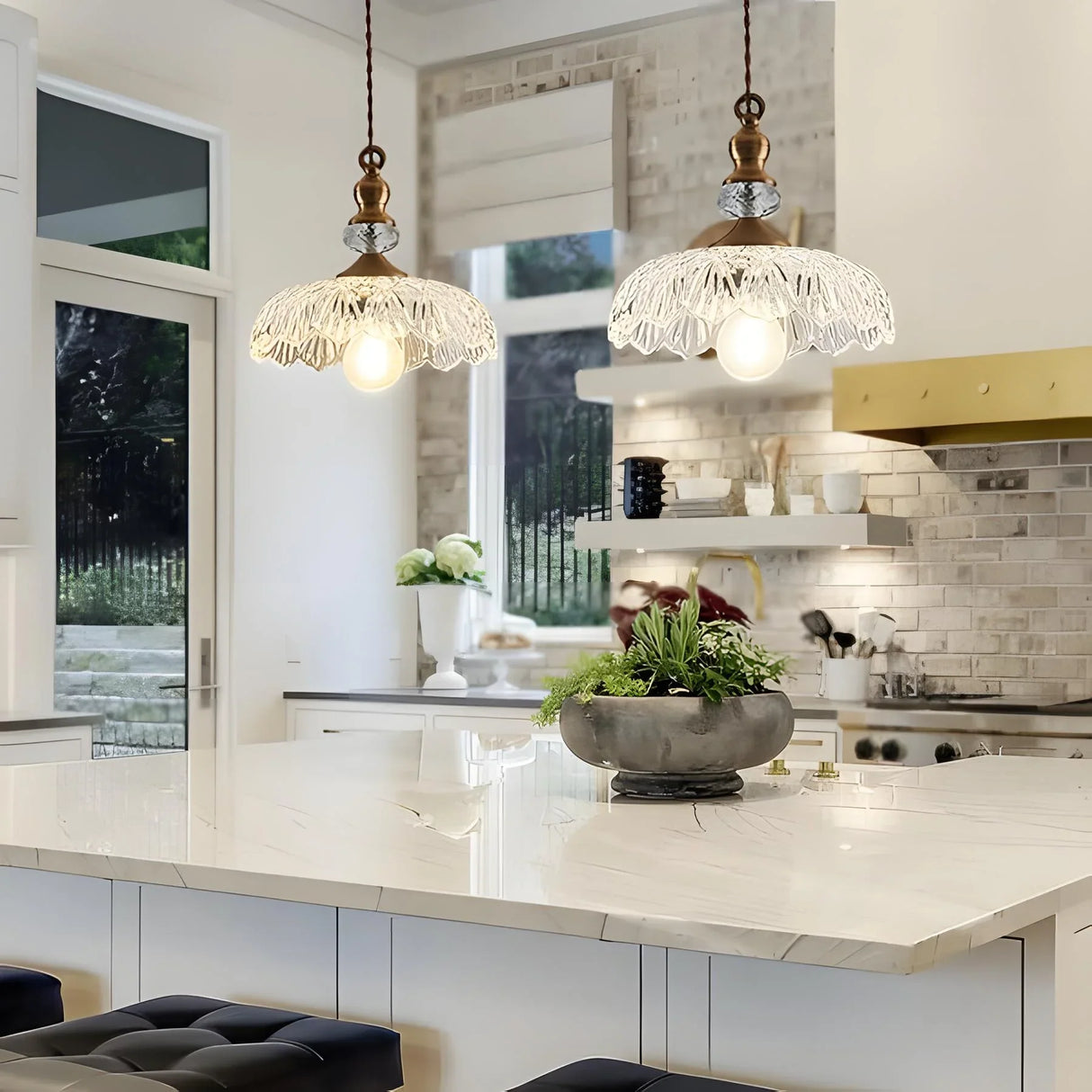 Transparent glass flower pendant light with brass fitting on a light background