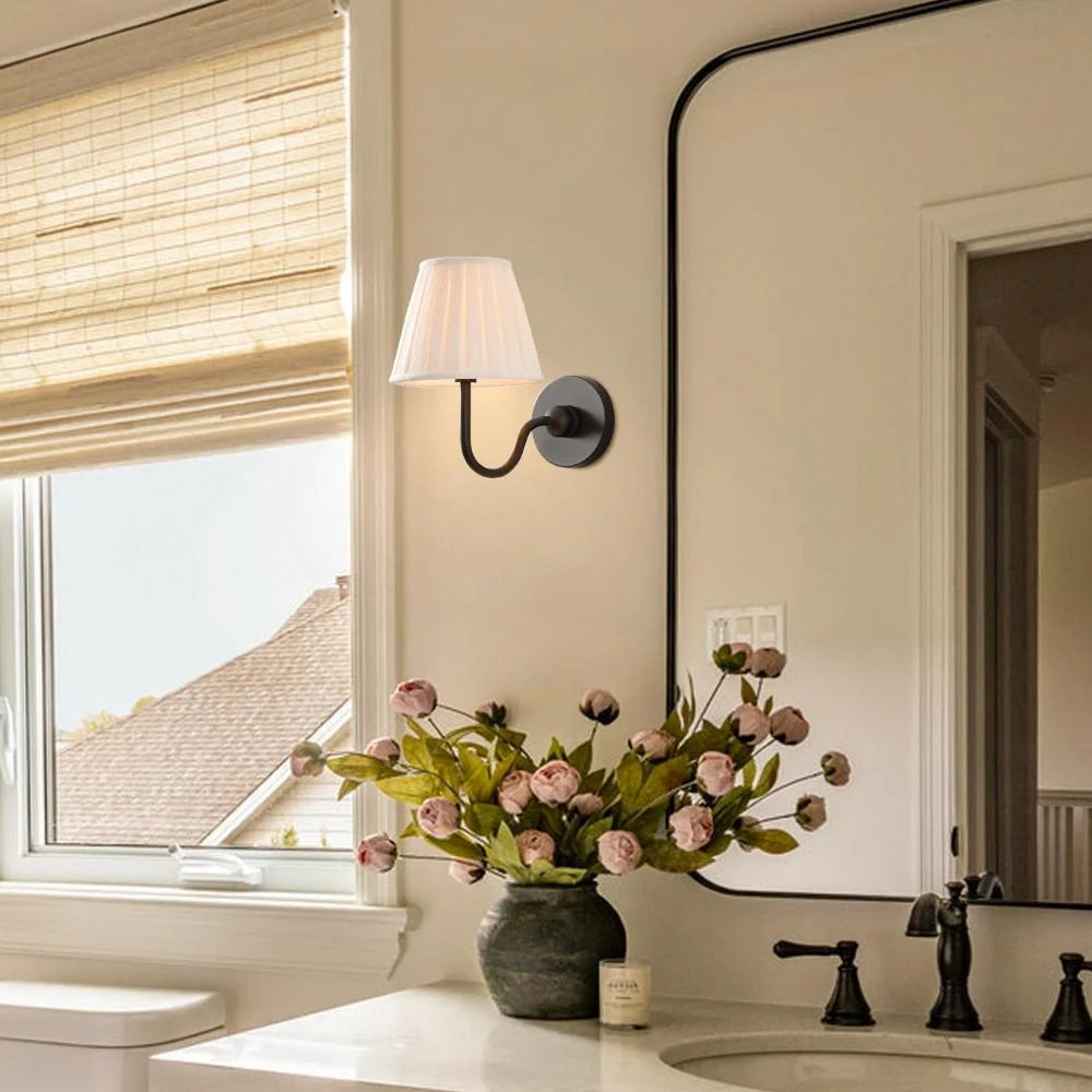 Single-head wall sconce with tapered pleated fabric shade and warm bulb glow, green shade close-up 18