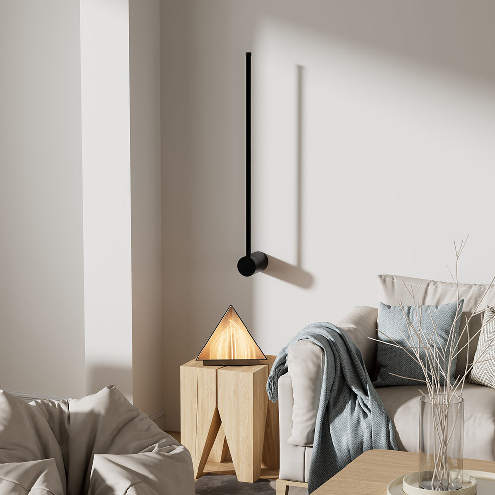 Single angled black LED wall lamp above a cream sofa