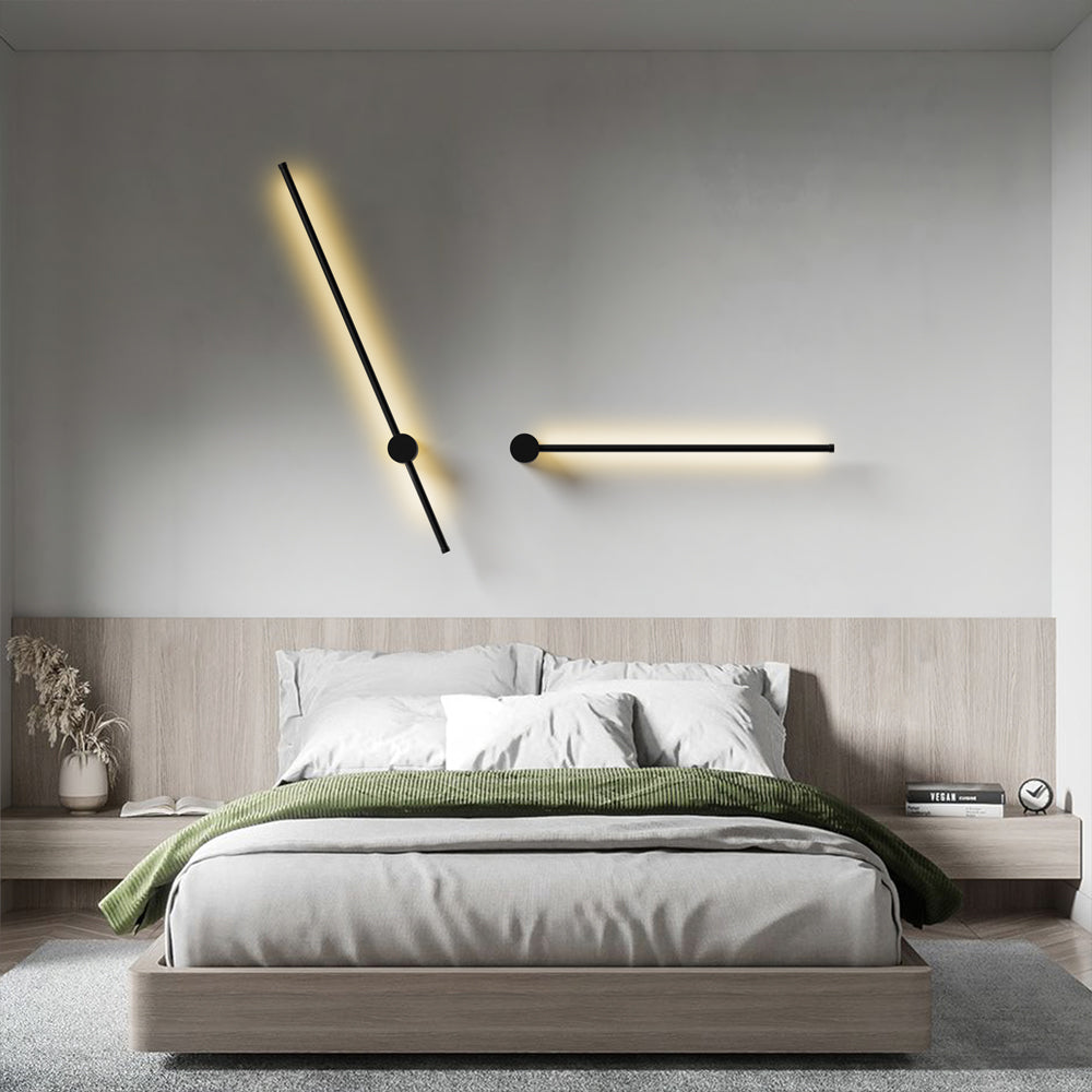 Two angled black wall lights above a bed with a wooden headboard