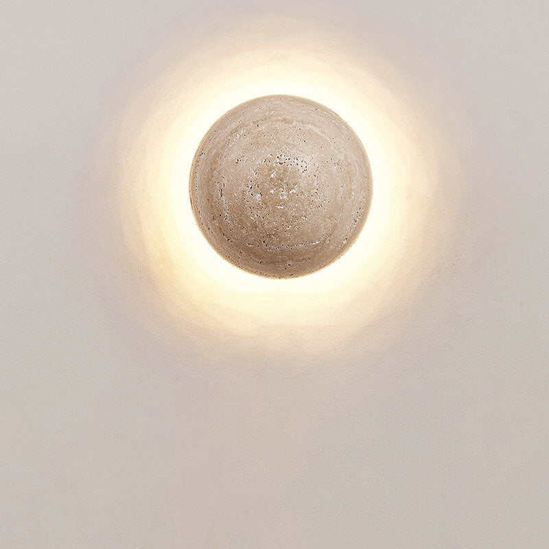 Round travertine wall sconce shown at 5.91 in / 15 cm across