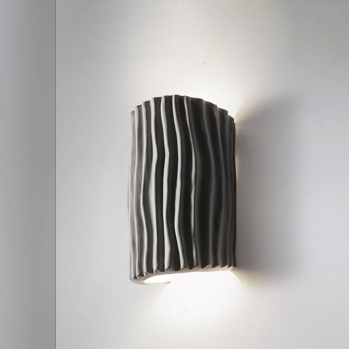 Gray striped resin wall sconce product shot on a light wall