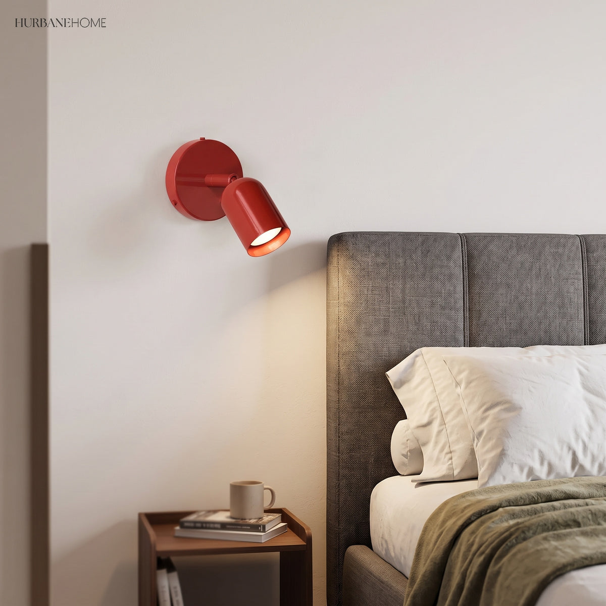 Red spotlight wall sconce mounted beside an upholstered headboard as a bedside reading light