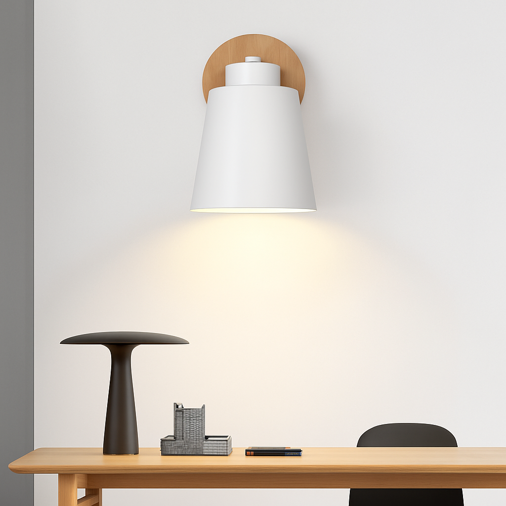 White sconce lit close up against a pale wall above a desk