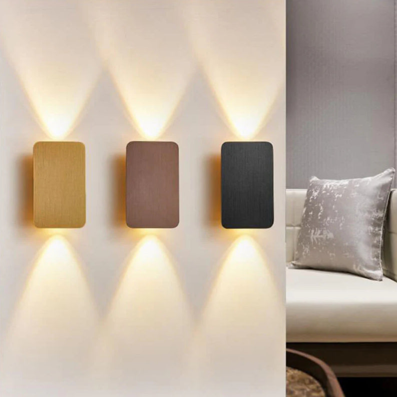 Gold rectangular up and down wall sconce shown against a grey wall