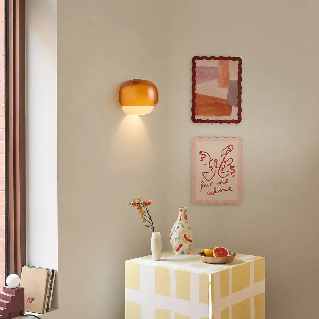 Amber glass sconce lighting a cosy corner near a reading chair