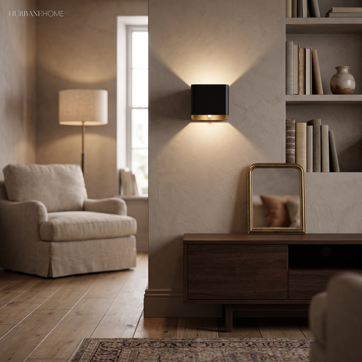 Black cube wall sconce lit on a wall beside an armchair