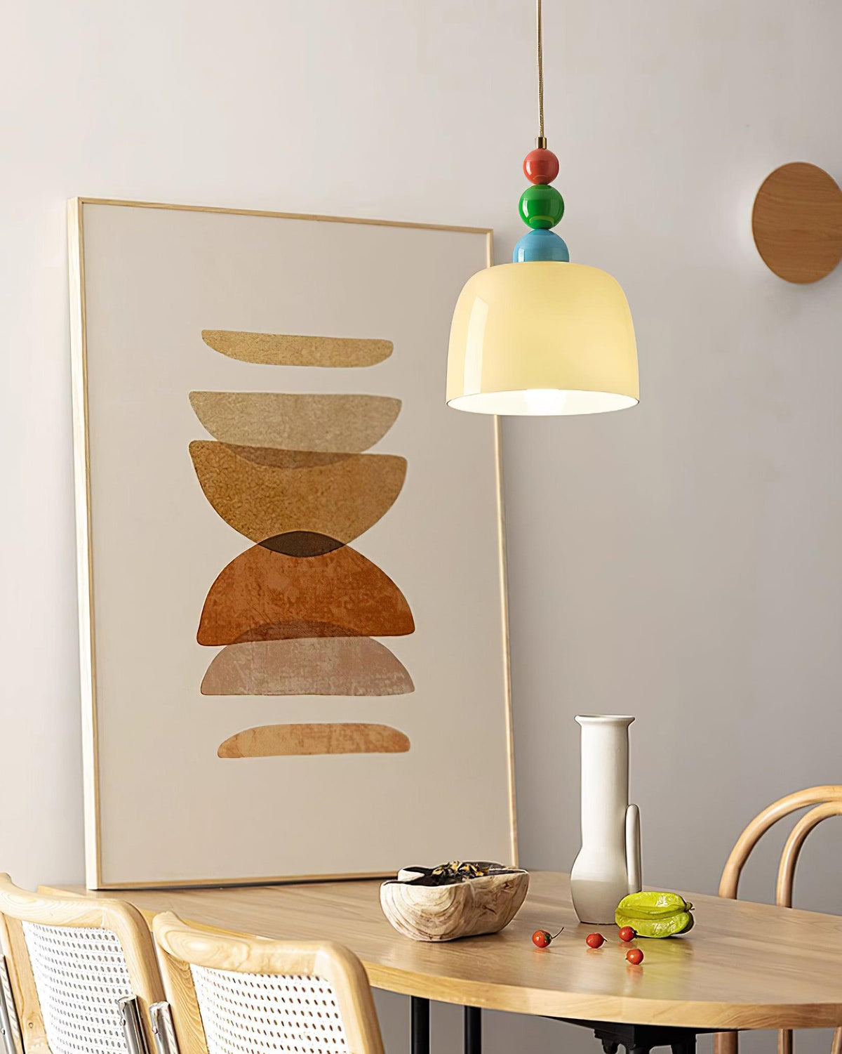 Beaded pendant above a round dining table beside a large abstract artwork