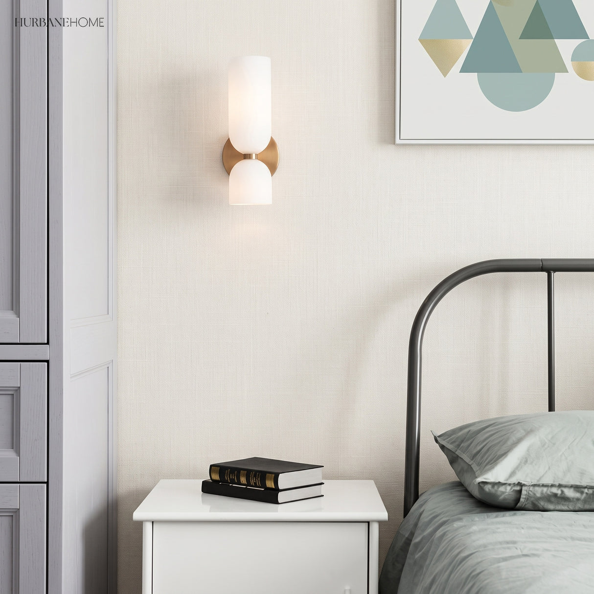 Glass wall sconce beside a bed and bedside table in a light bedroom