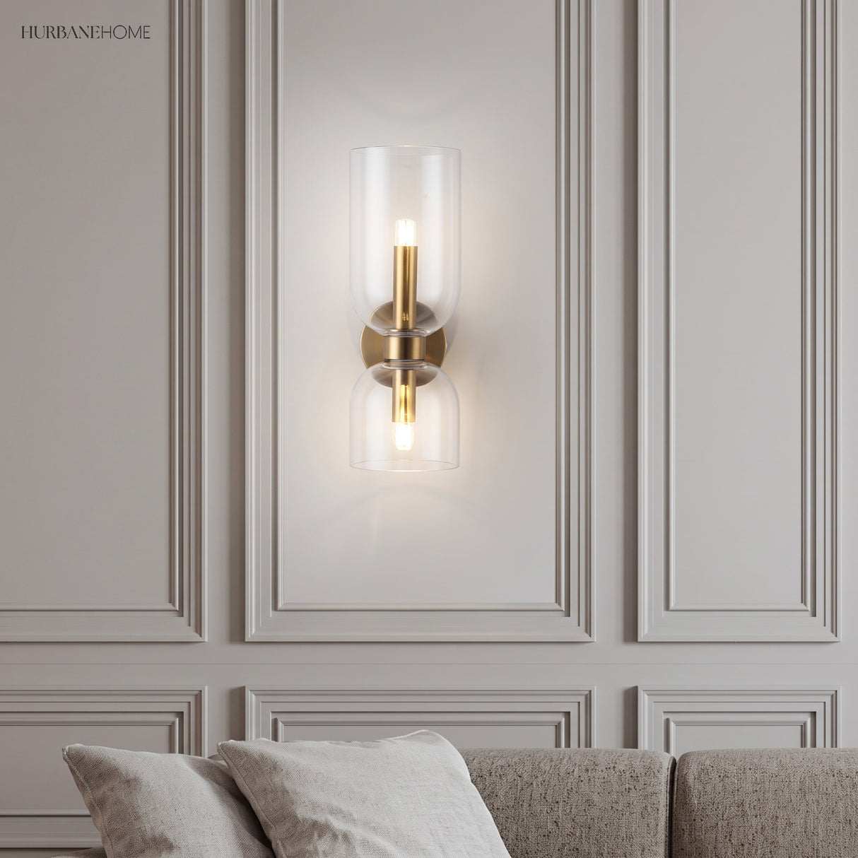 Glass wall sconce on a moulded wall above a sofa in a living room