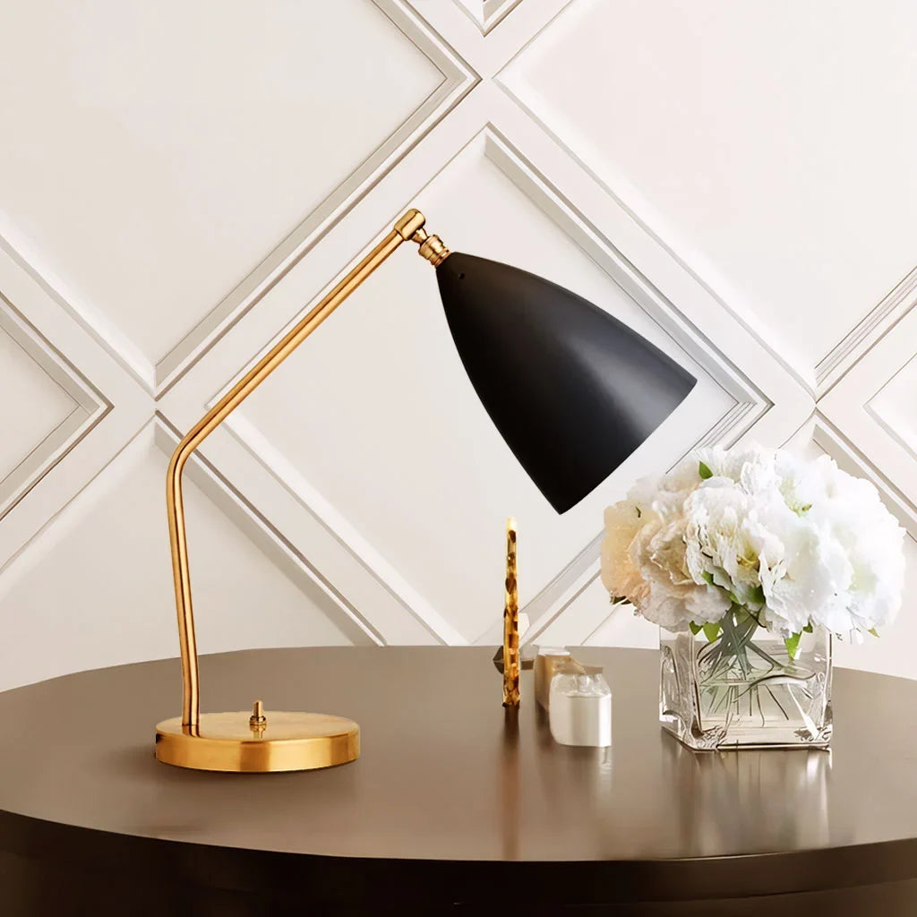 Black shade brass table lamp on a dark round table