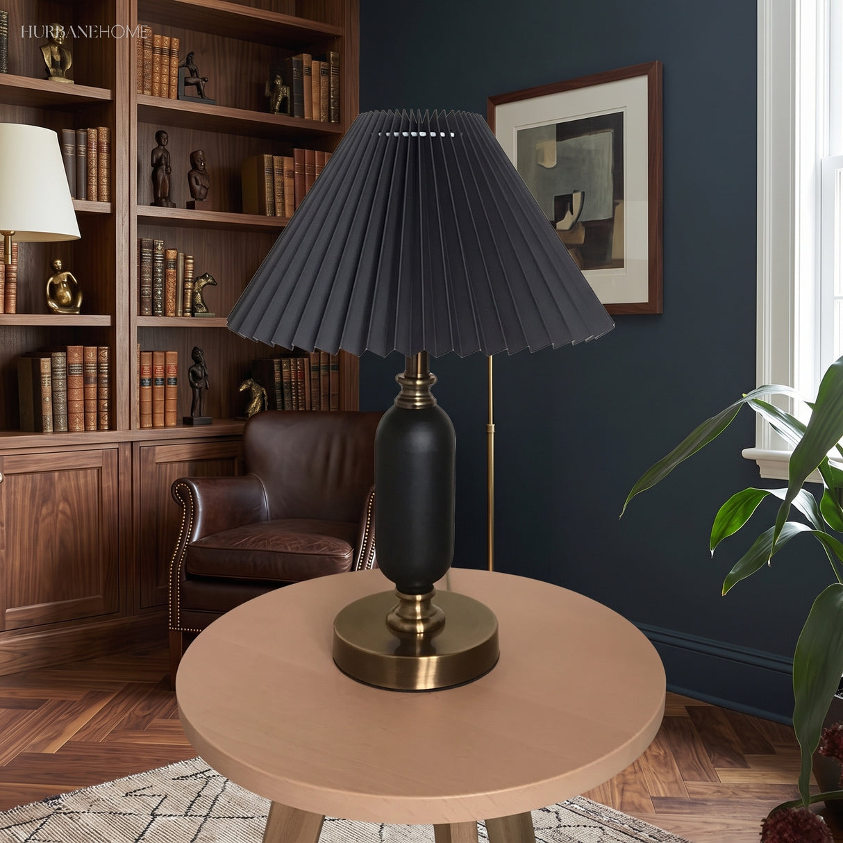 Black pleated table lamp with brass base in a navy library