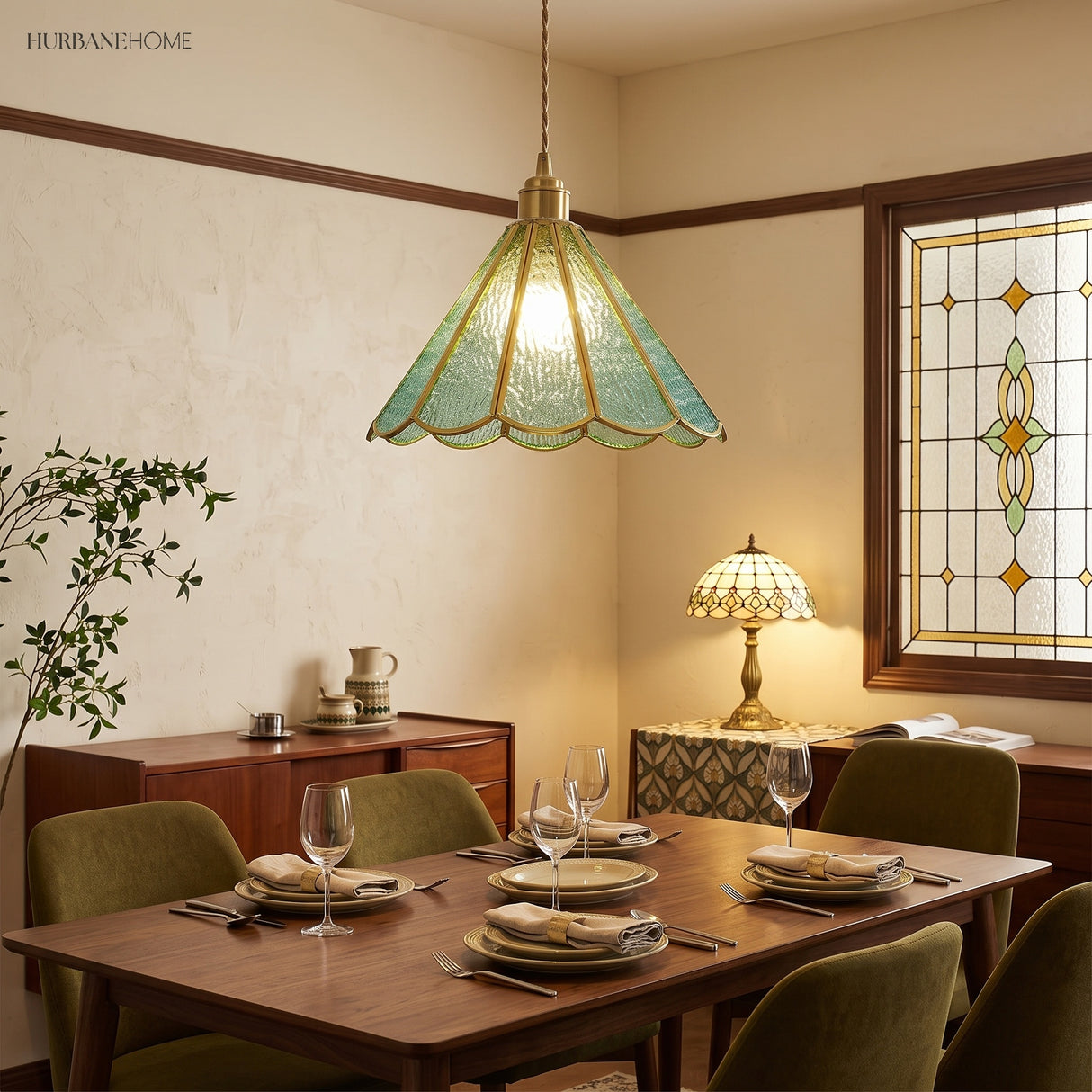 Blue glass pendant above a set dining table in a room with leaded windows