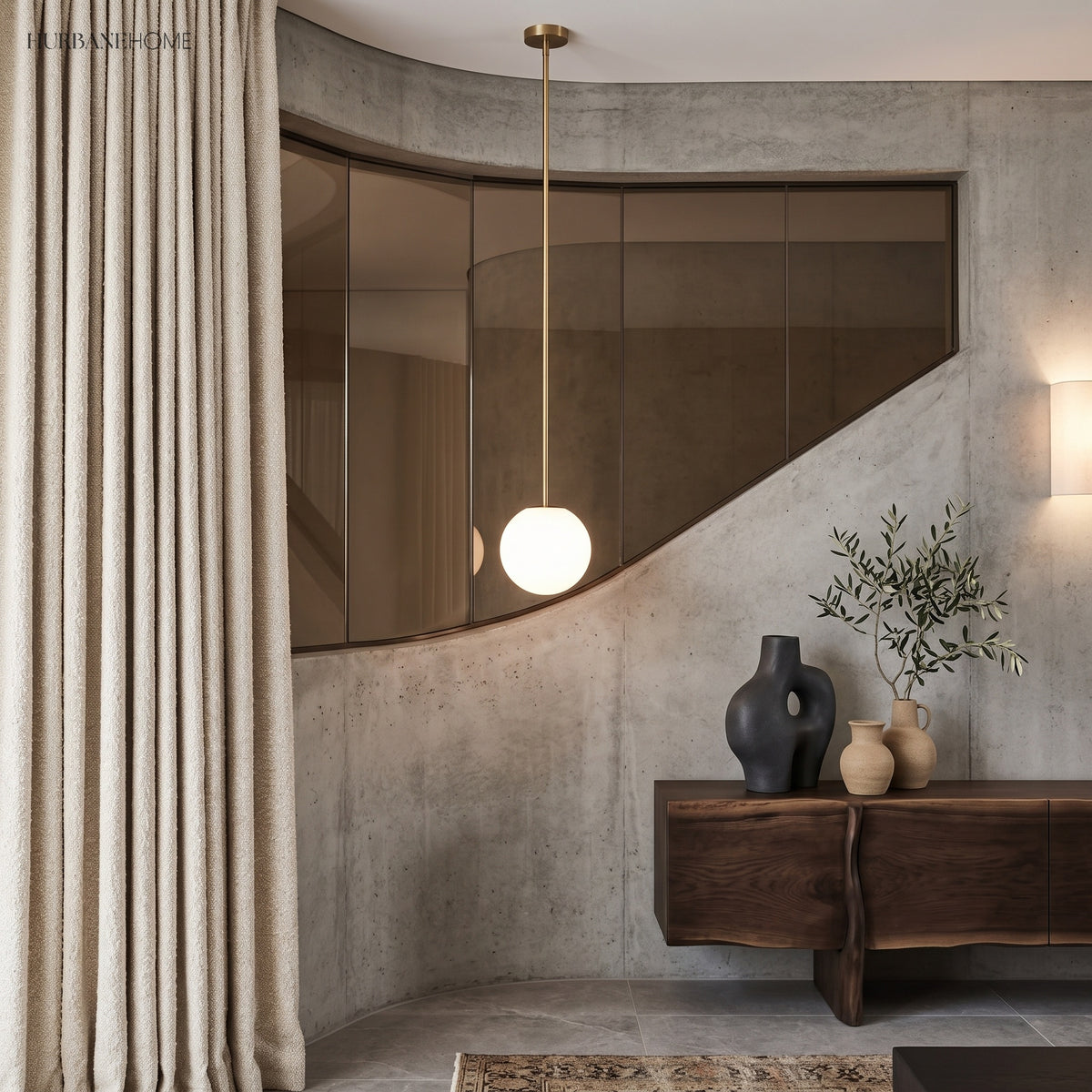 Brass stem globe pendant beside a curved mirror and linen curtain