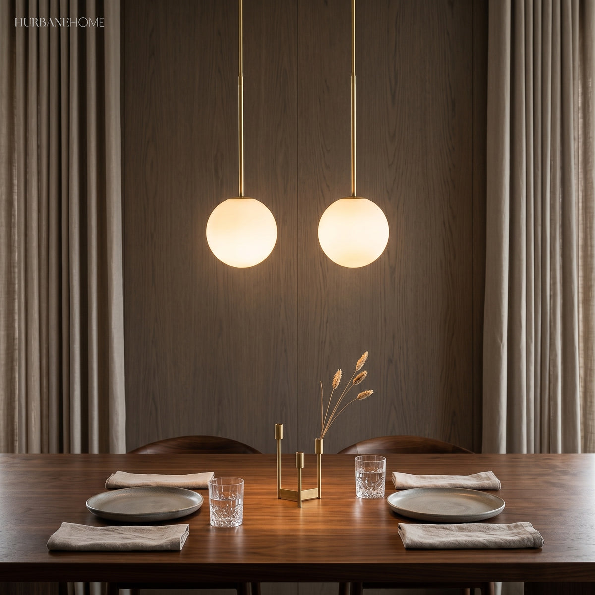 Two brass stem globe pendants above a walnut dining table setting