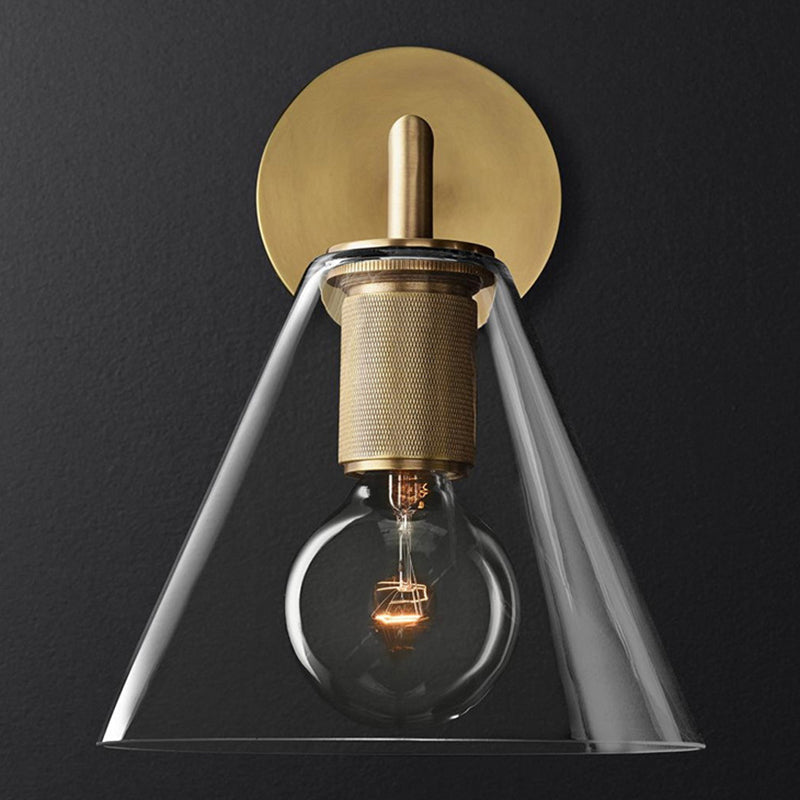 Clear glass cone shade sconce lit against a charcoal background