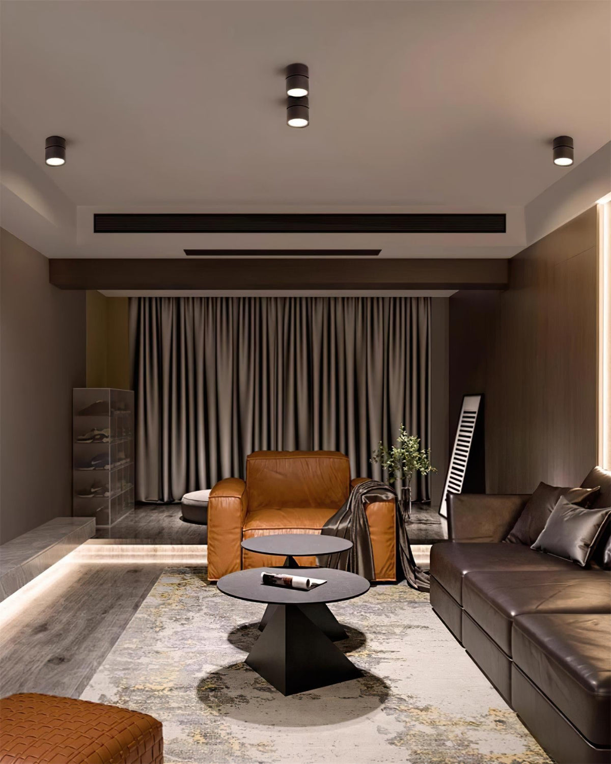 Ceiling spot lights above a living room with a tan armchair and patterned rug