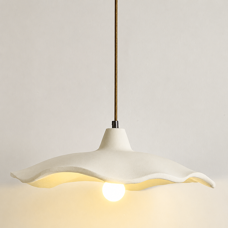 Studio shot of a lit cement flower pendant light with a warm bulb glow