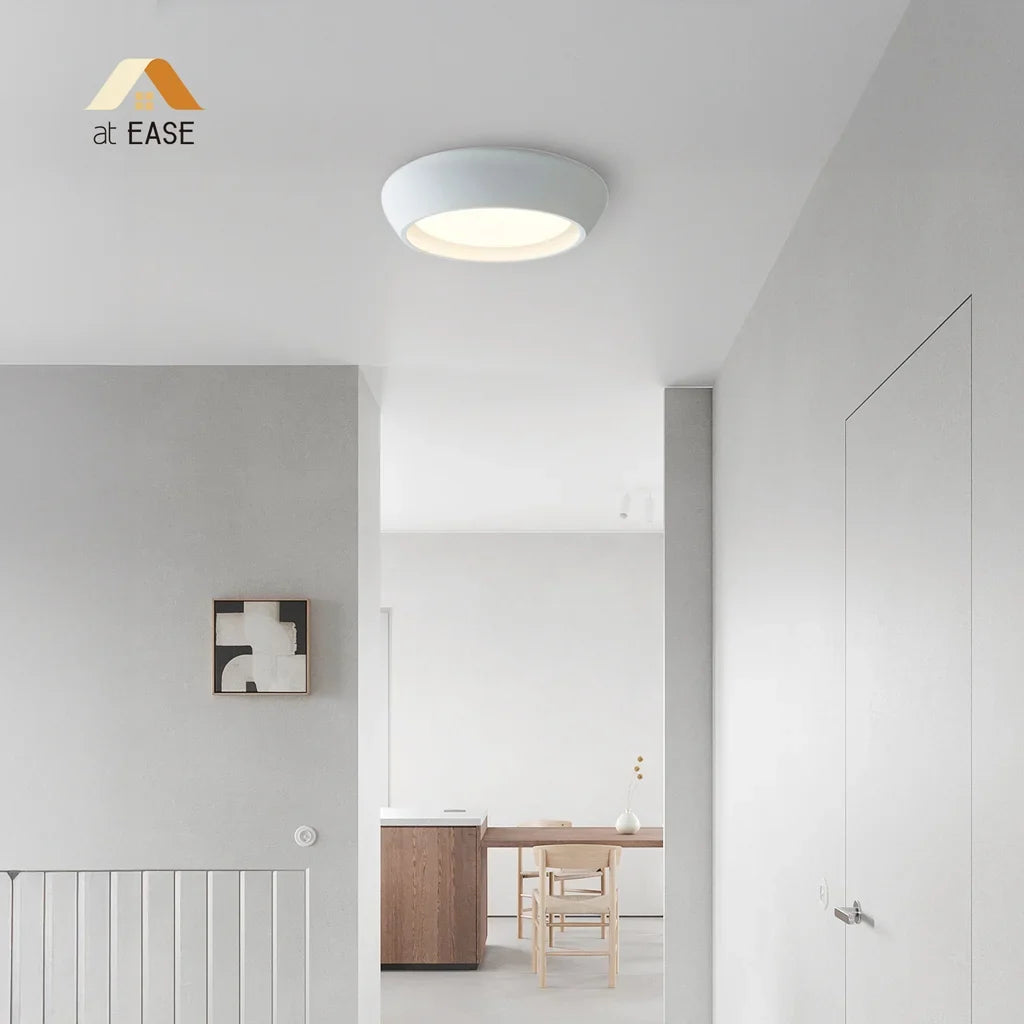 Cement ceiling light mounted flat against a neutral ceiling in a modern room