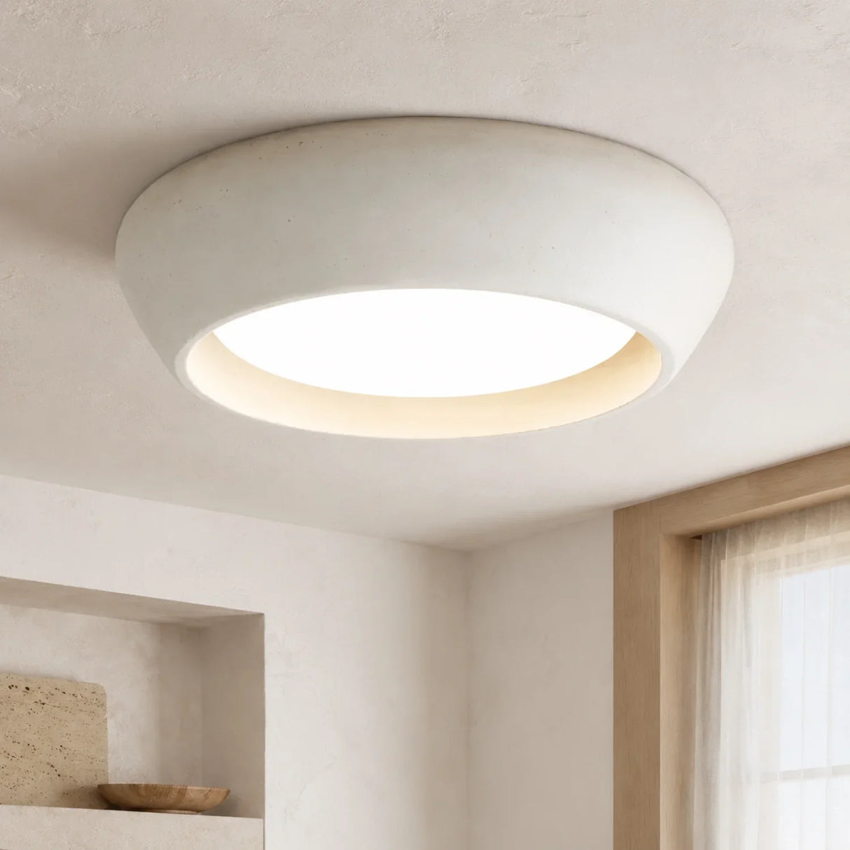 Studio view of the rounded cement dome ceiling light with a soft glowing centre