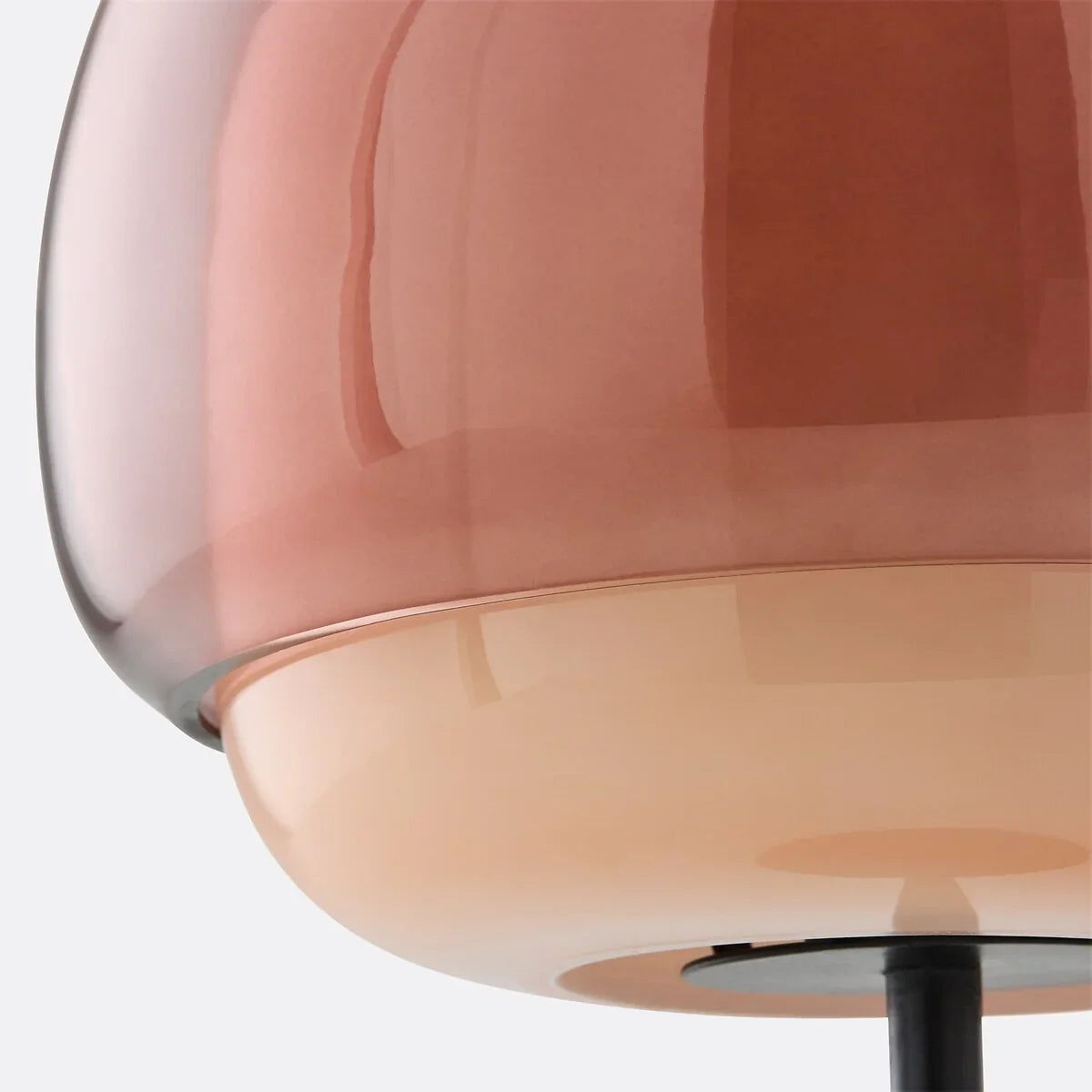 Close view of the round metal base and lower stem of the lamp