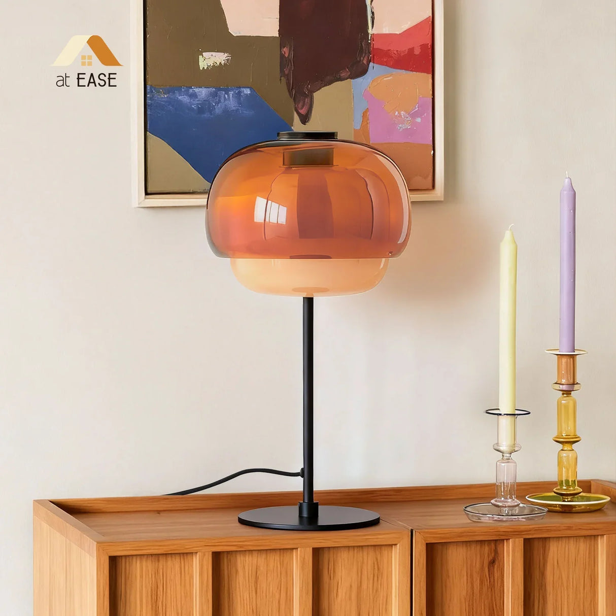 Orange glass table lamp viewed from the front with metal base