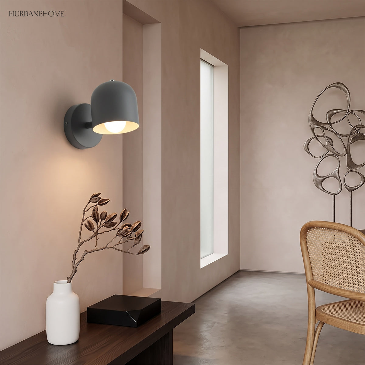Grey macaron wall sconce lit in a narrow hallway beside a window