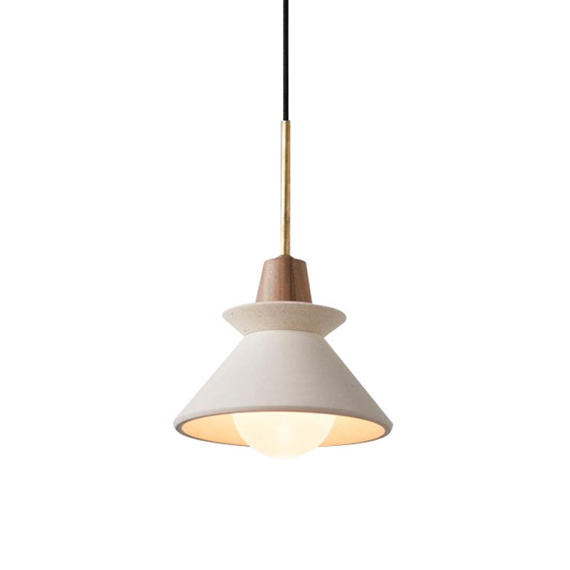 Small white cement cone pendant lit against a plain pale background