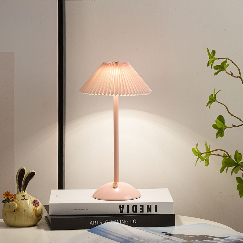 Gold cordless table lamp shown at an angle with slim stem and domed base