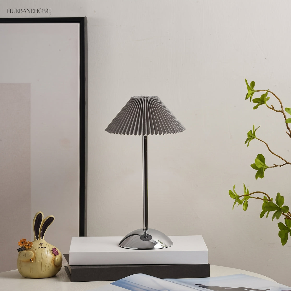 Silver base table lamp with grey pleated shade by a framed print