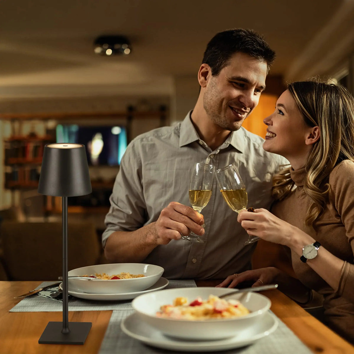 Couple dining at a table lit by a black cordless lamp