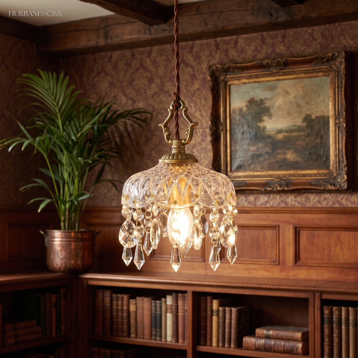 Crystal pendant light glowing in a wood-panelled study with a plant