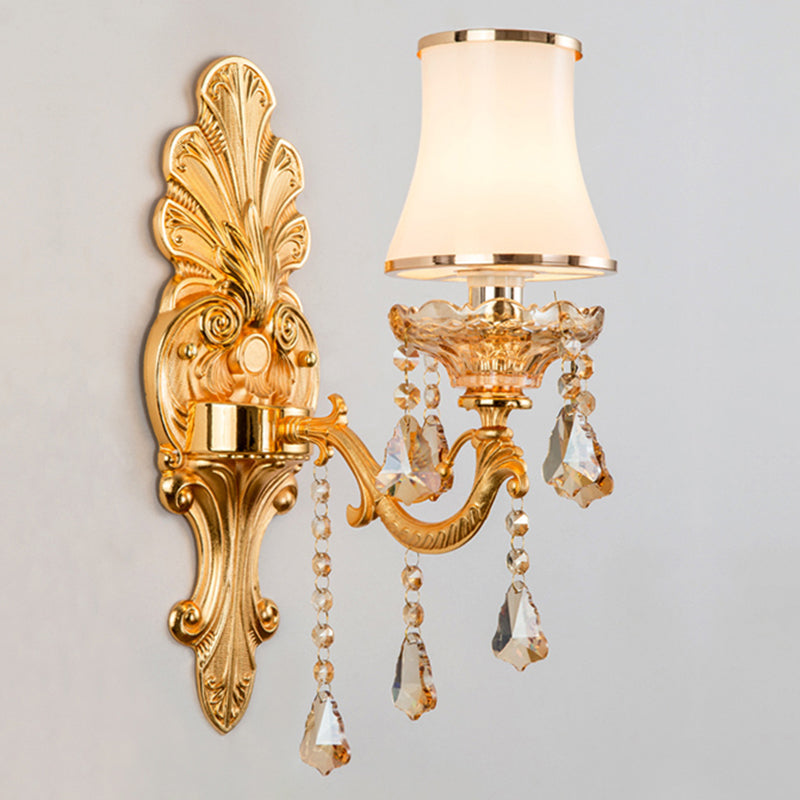 Gold single light sconce with an opal glass shade, studio view