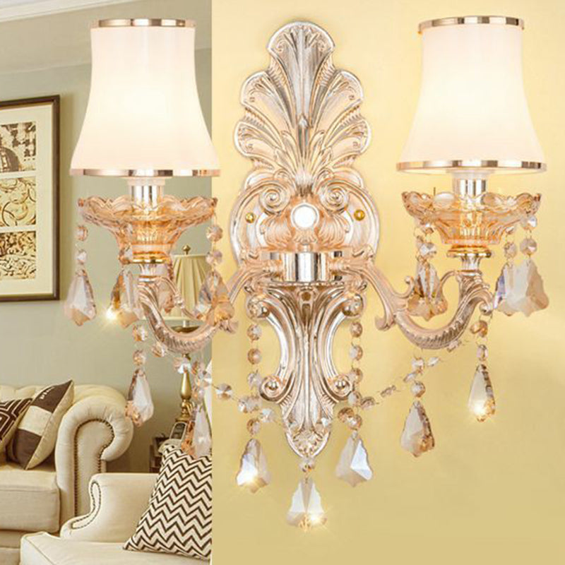Silver sconce with pleated shades lighting a traditional living room
