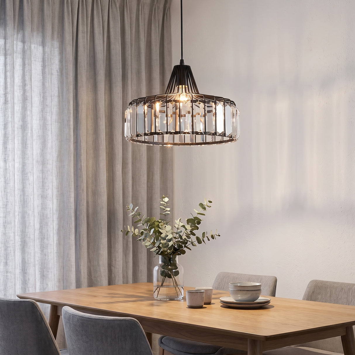 Black crystal drum pendant lighting an oak dining table beside grey curtains