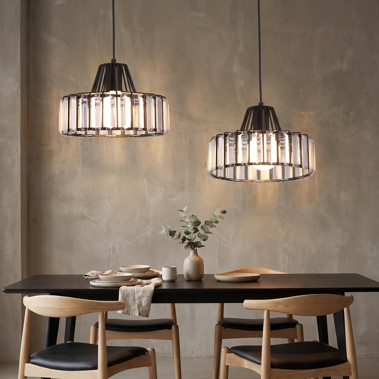 Two black framed crystal pendants above a dark dining table and timber chairs