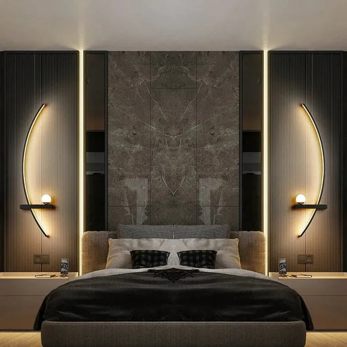 Curved LED wall light casting a soft warm glow in a dark bedroom