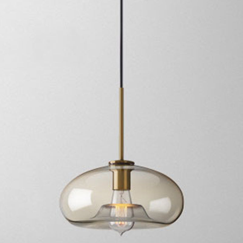 Studio shot of the wide flattened amber urn shade with a brass cap