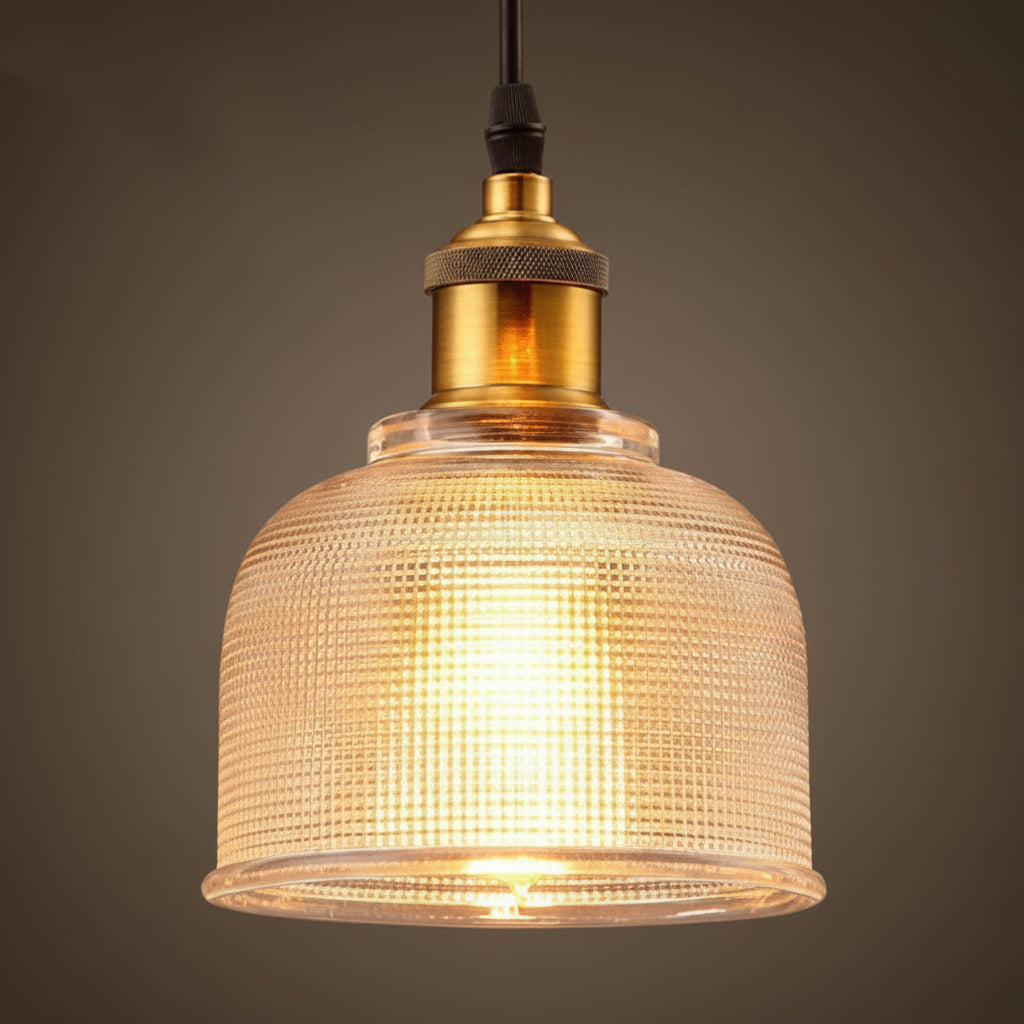 Amber bell pendant lit warm with a brass socket and black cord