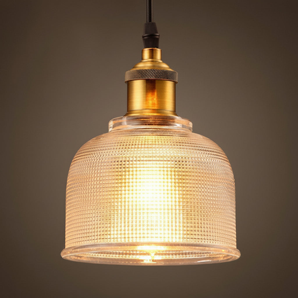 Clear bell pendant lit warm showing the ribbed glass texture