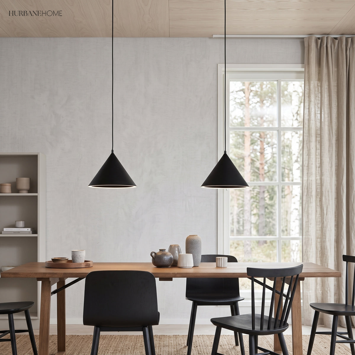 Two black cone pendants above a dining table and black chairs