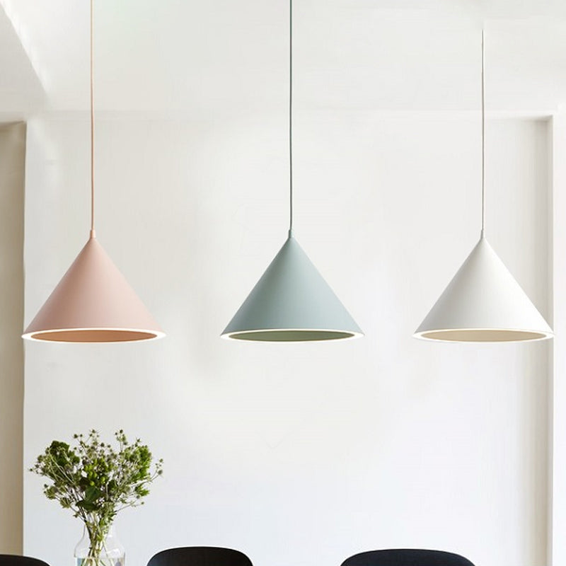 Pink, green and white cone pendants against a white gallery wall