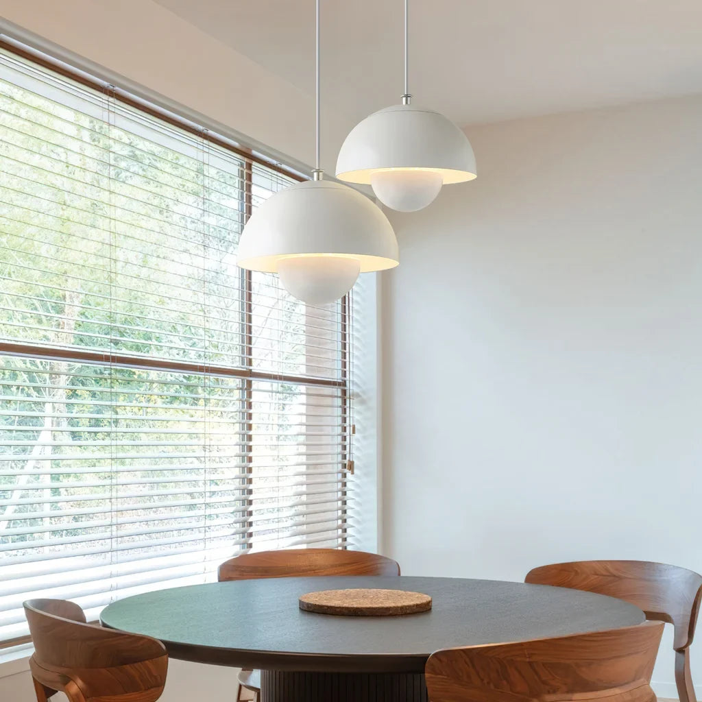 Two bud metal pendant lights paired above a modern dining table
