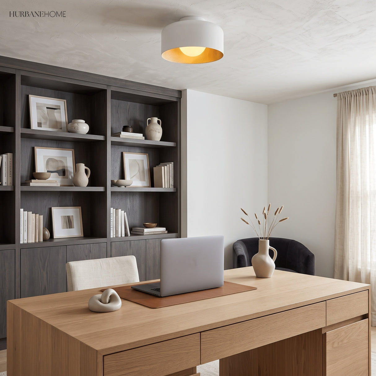 Drum ceiling light with lit wood grain interior above a pale timber desk