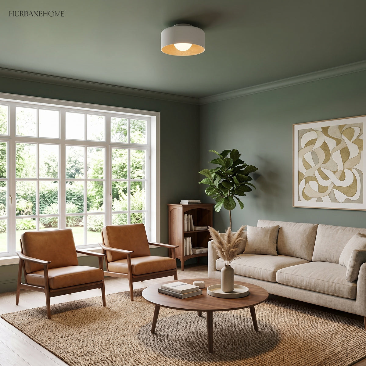White drum ceiling light lit in a green walled room with leather armchairs