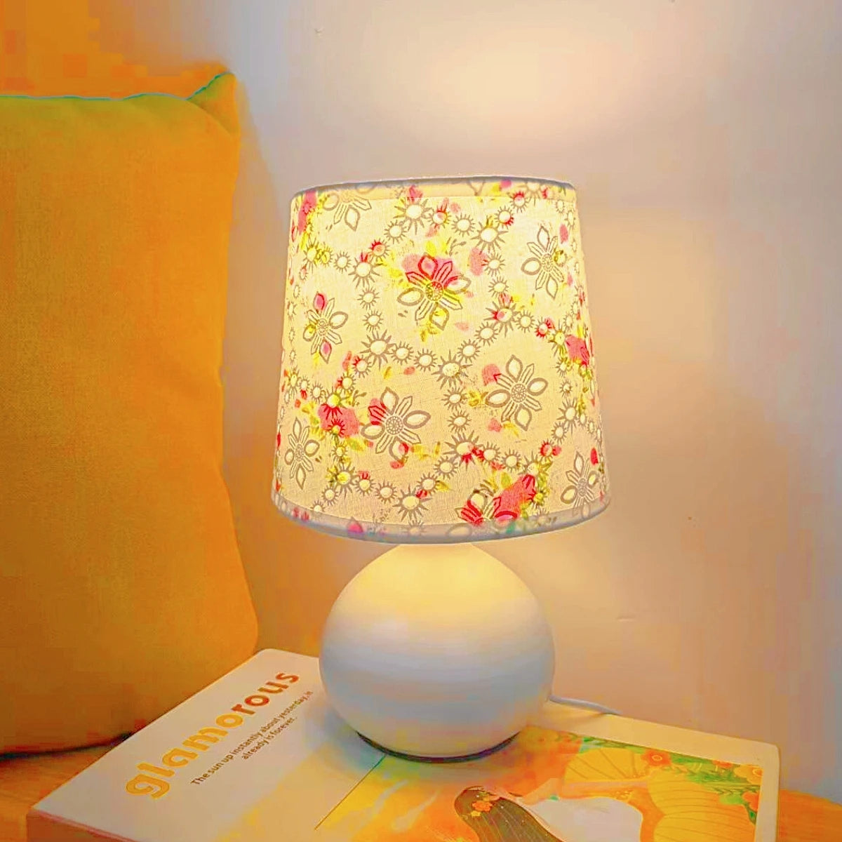 Floral desk lamp with white shade placed on nightstand for reading